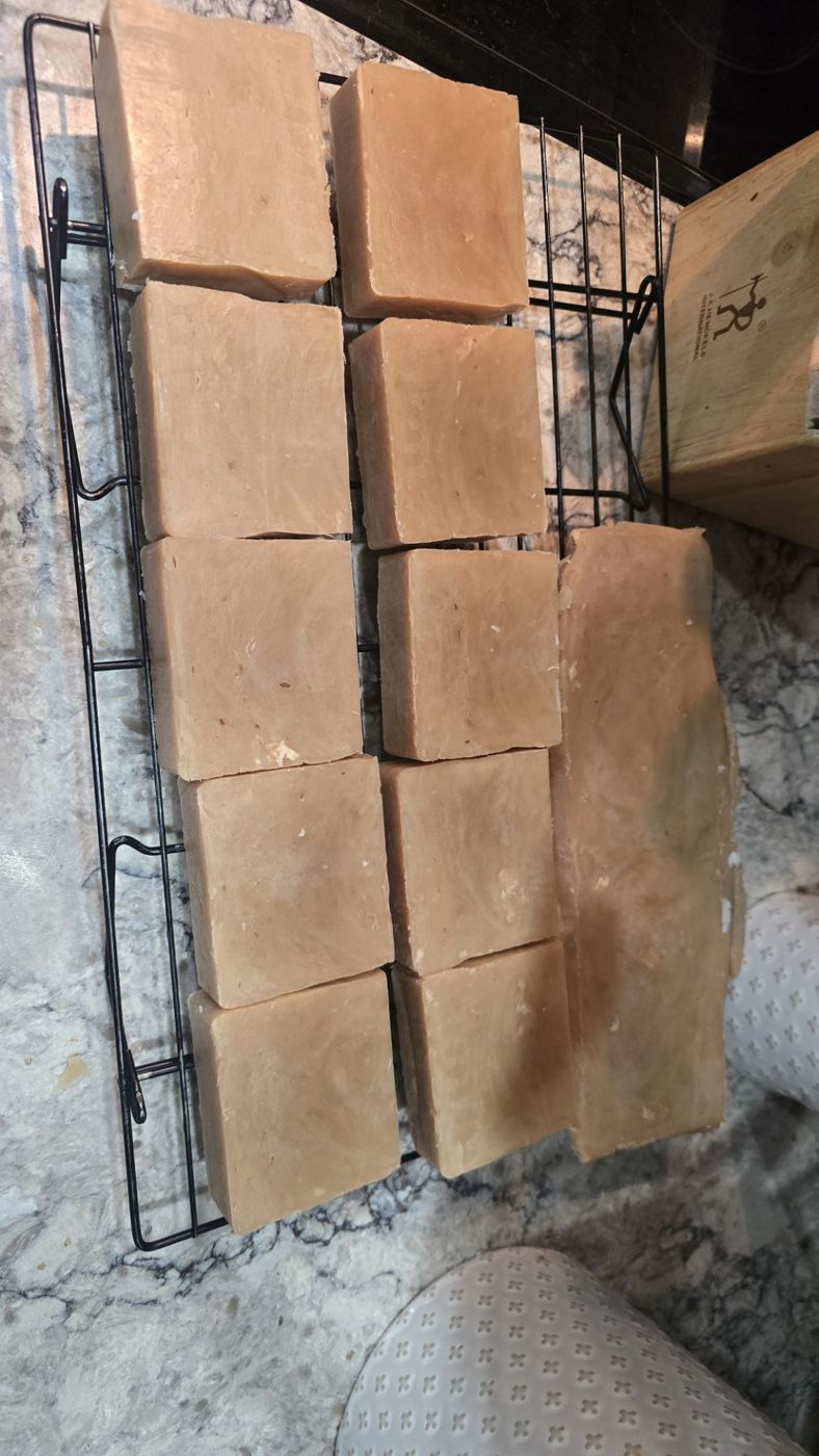 Bars of goat milk soap curing on a rack